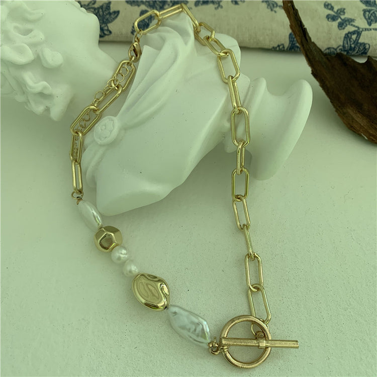 a gold necklace on a white statue