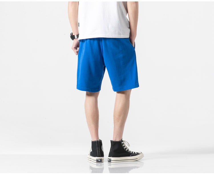 a person wearing blue shorts and black shoes