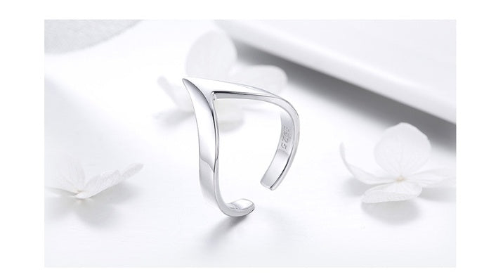 a silver ring on a white surface