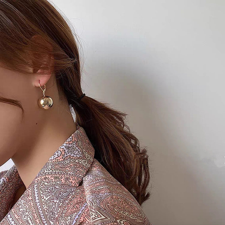a woman wearing a gold earring