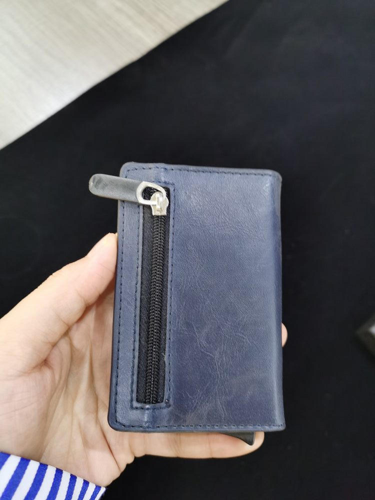 a hand holding a blue wallet
