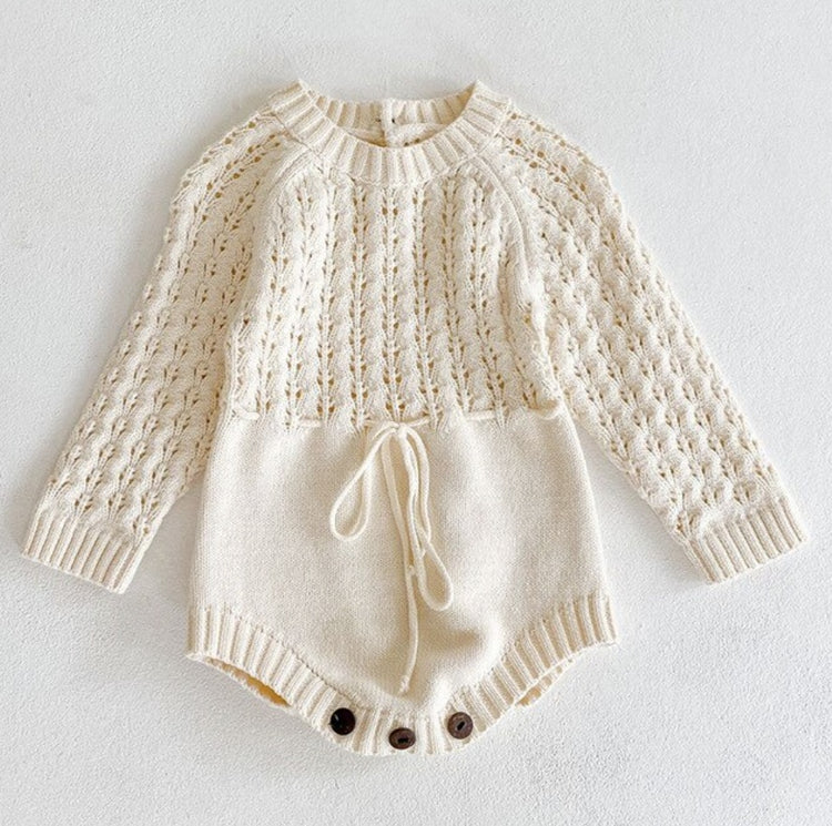 a white knitted baby romper
