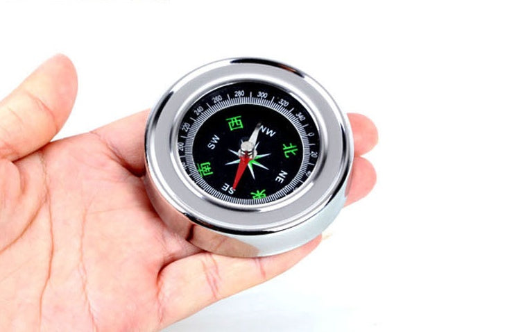 a hand holding a compass
