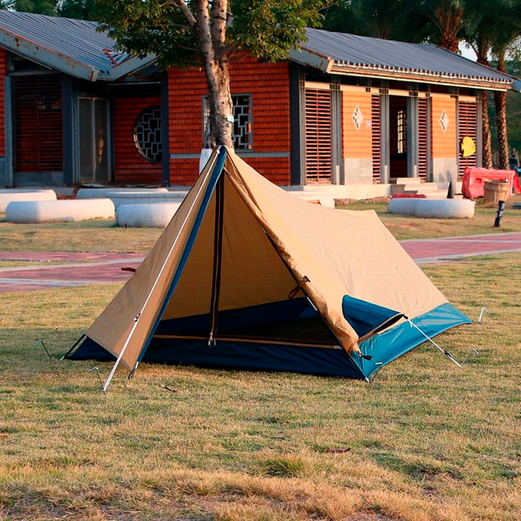 a tent on grass in front of a building