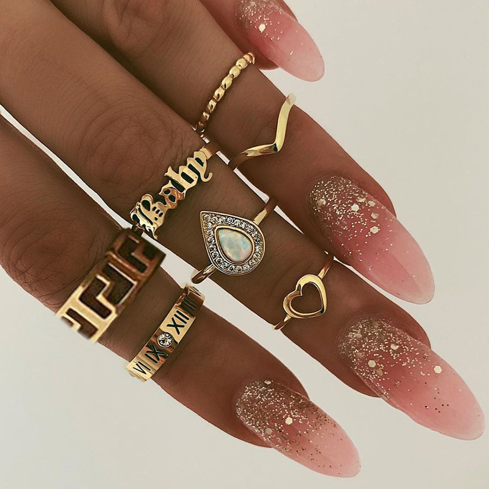 a hand with long nails and many rings