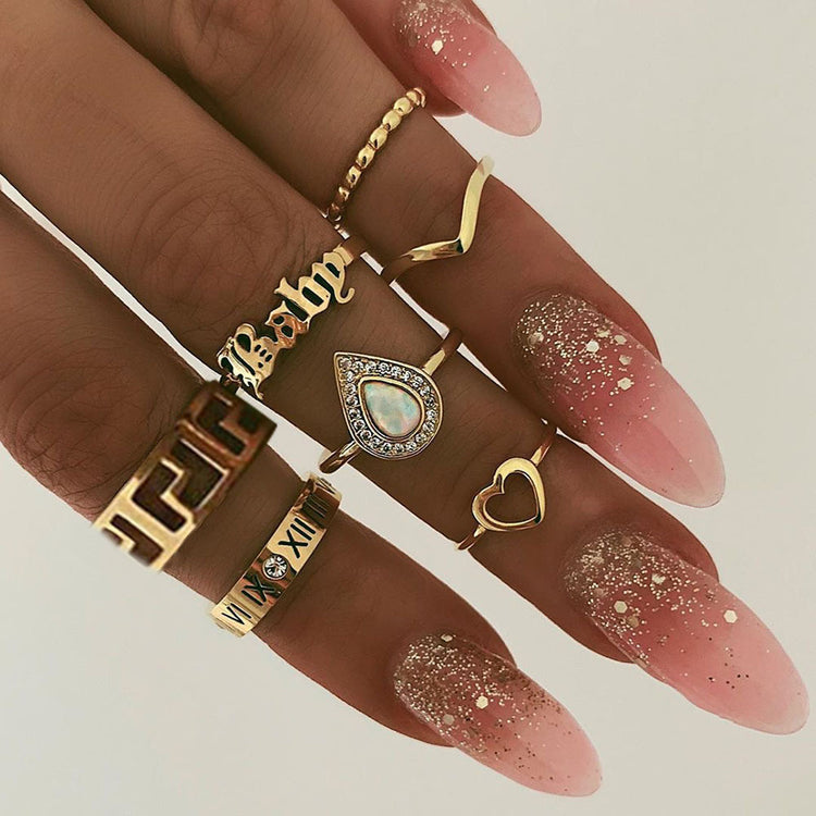 a hand with long nails and many rings