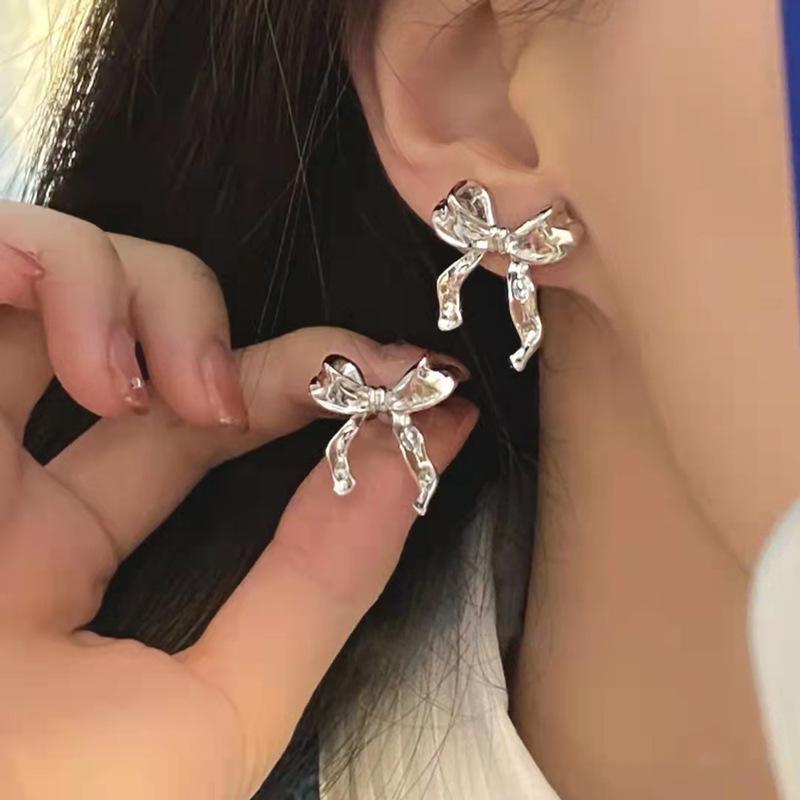 a person wearing earrings with bows