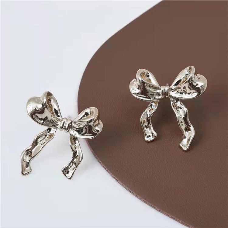 a pair of silver bows on a brown surface