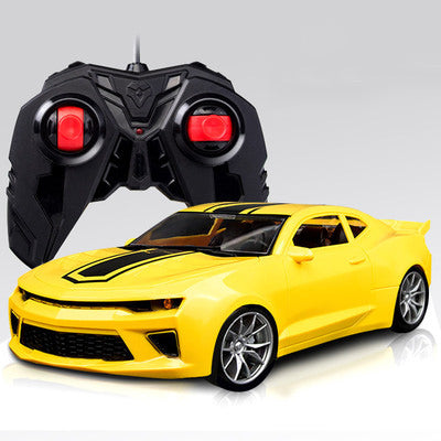a yellow toy car next to a black remote control