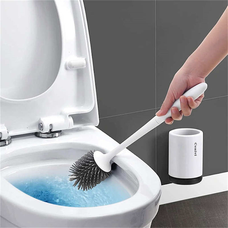 a hand holding a brush to a toilet