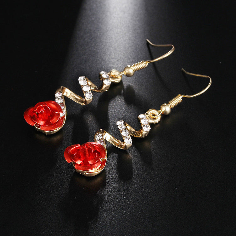 a pair of earrings with red flowers