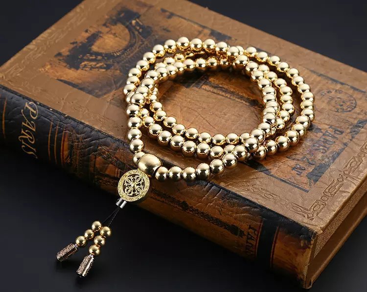 a gold beaded necklace on a book