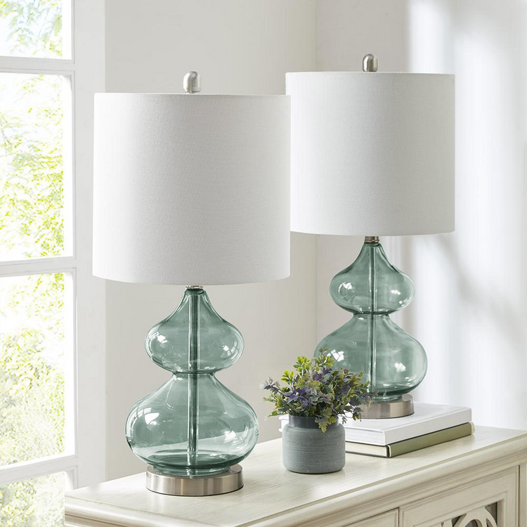 a table with two lamps and a plant on it