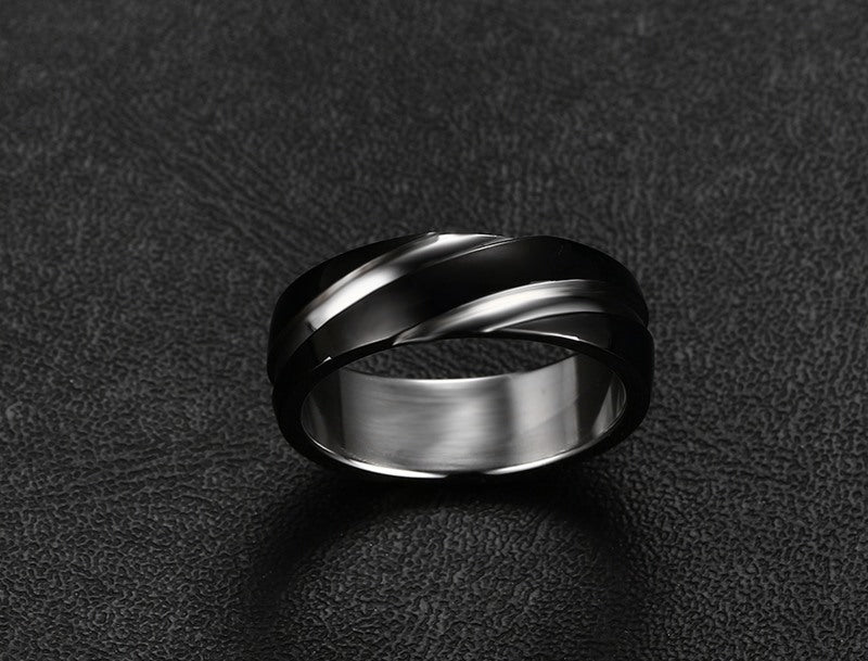 a silver ring on a black surface