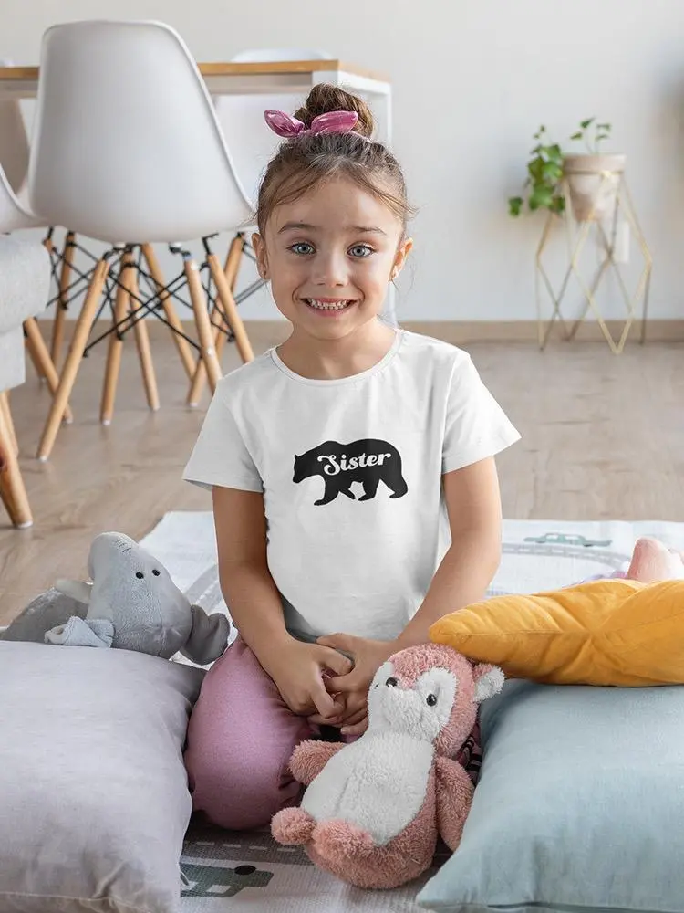 a girl sitting on a bed with stuffed animals