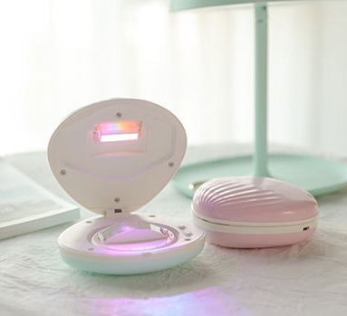 a pink and white device with a light on it