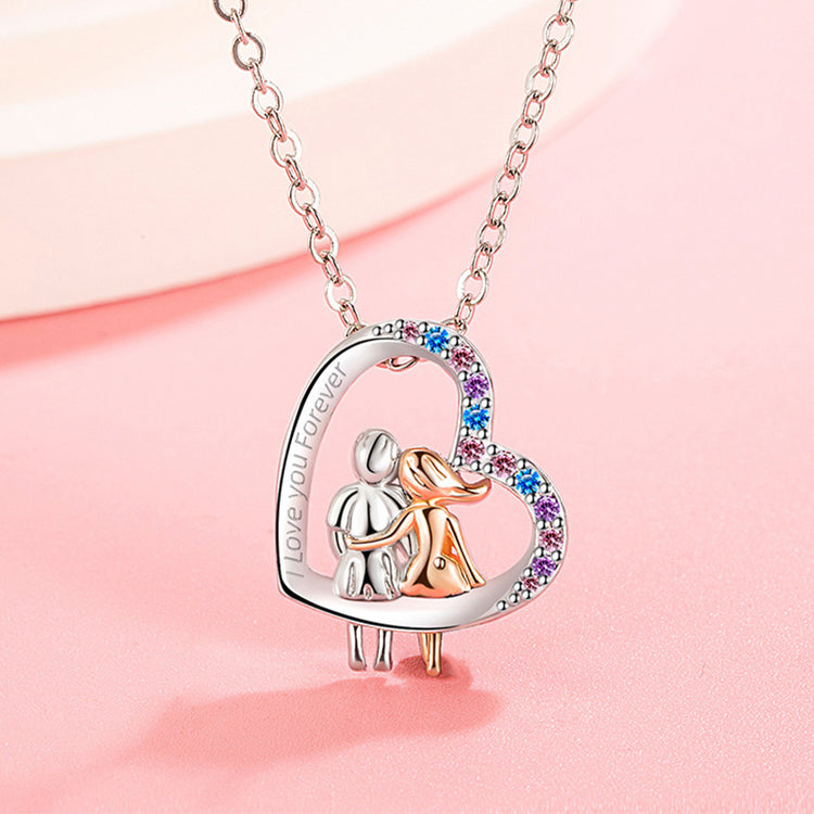 a necklace with a couple in a heart shaped pendant