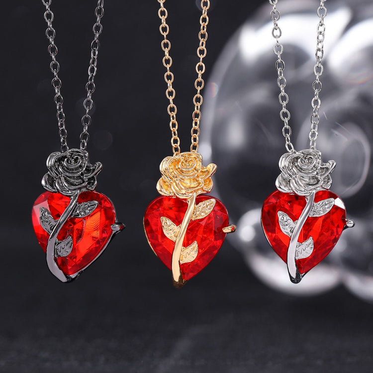 a group of necklaces with a red heart and a rose