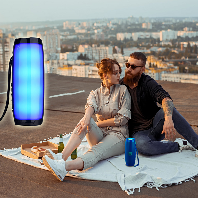 a man and woman sitting on a blanket on a rooftop