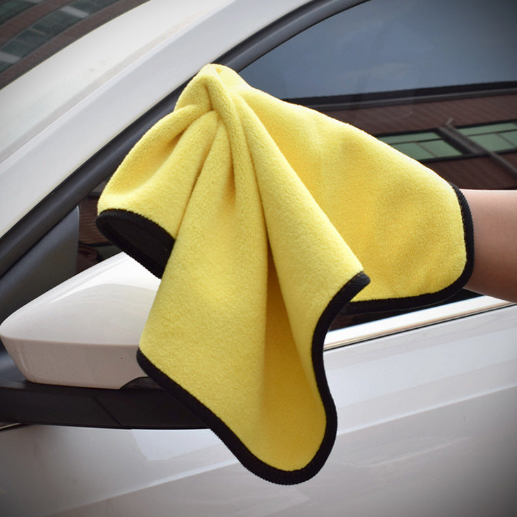 a hand holding a yellow towel