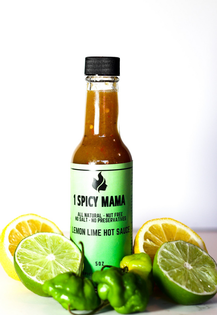 a bottle of hot sauce with lemons and limes