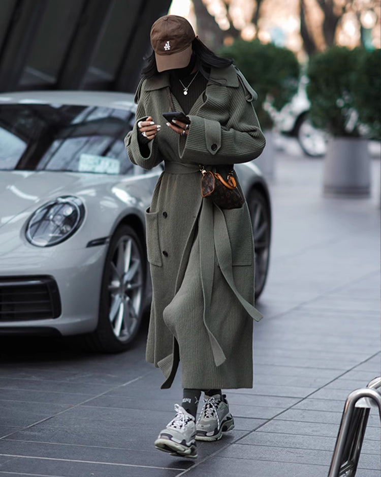 a woman in a long coat and hat
