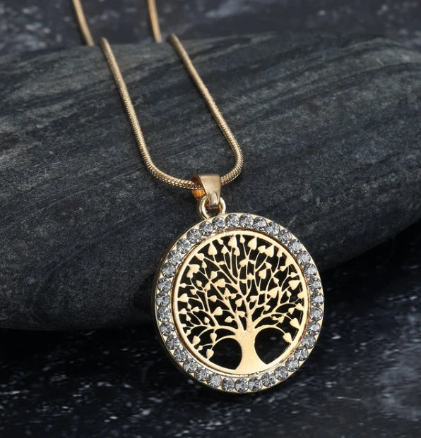 a gold necklace with a tree of life
