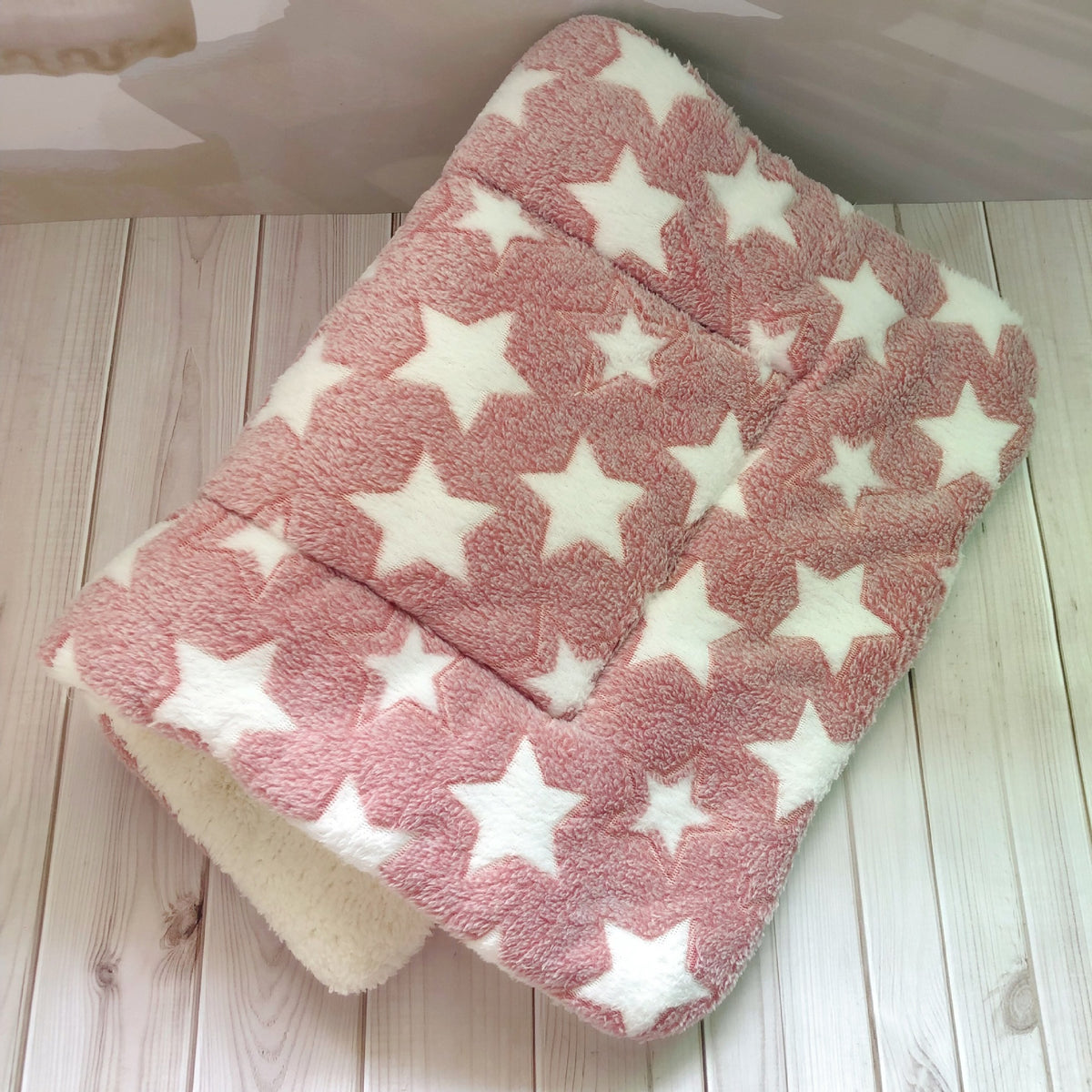 a pink and white blanket with white stars on it