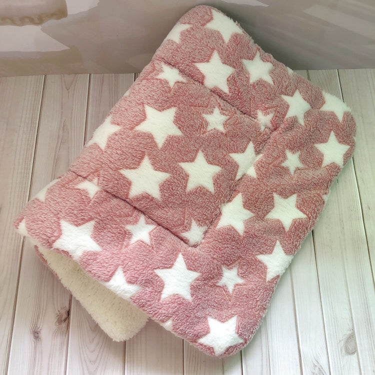 a pink and white blanket with white stars on it