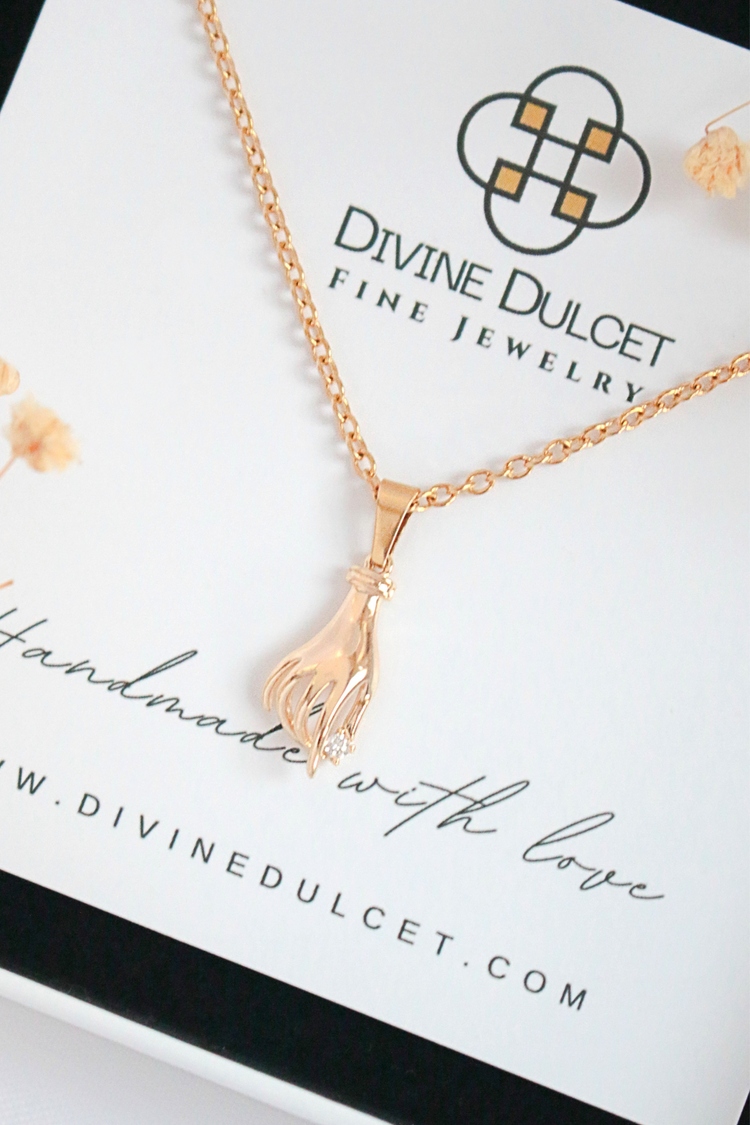a gold necklace with a diamond pendant on a chain