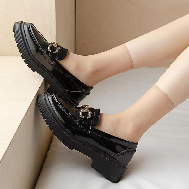 a person's feet wearing black shoes