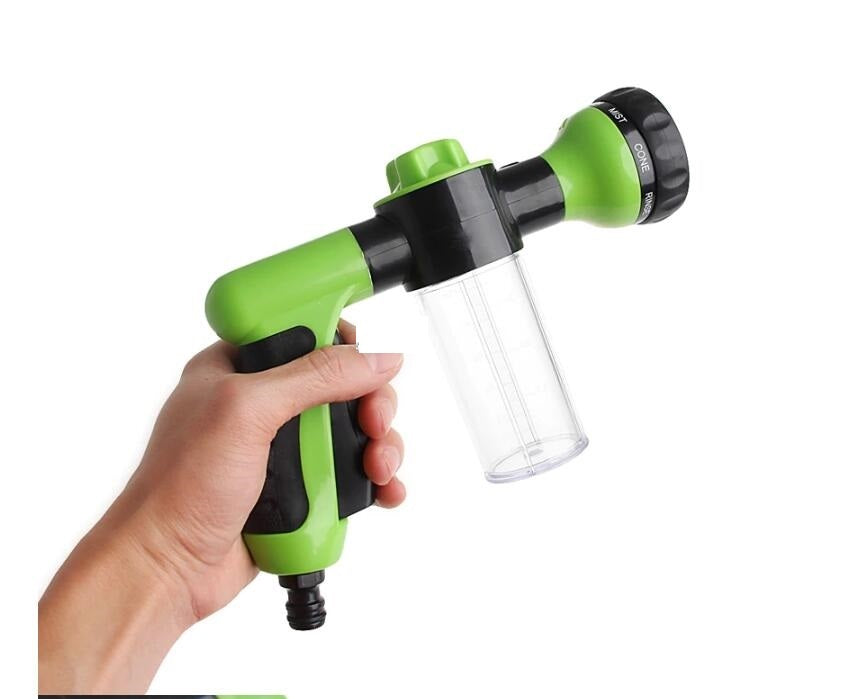 a hand holding a green and black water gun