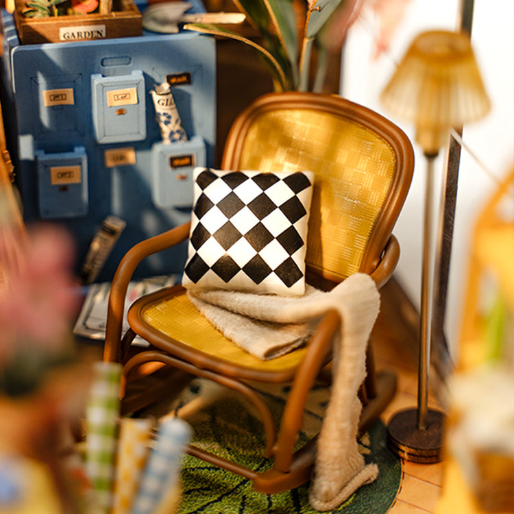 a doll house with a chair and a pillow