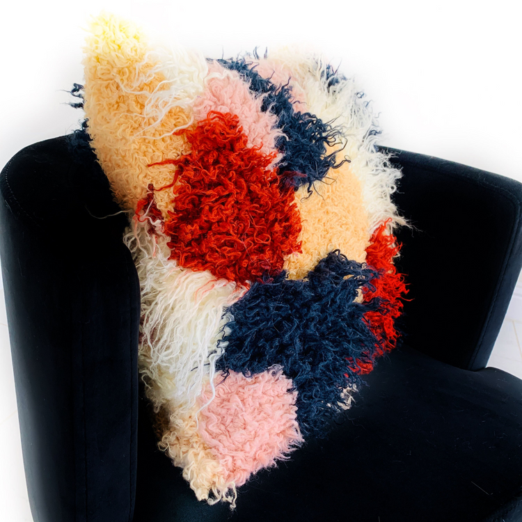 a colorful pillow on a chair