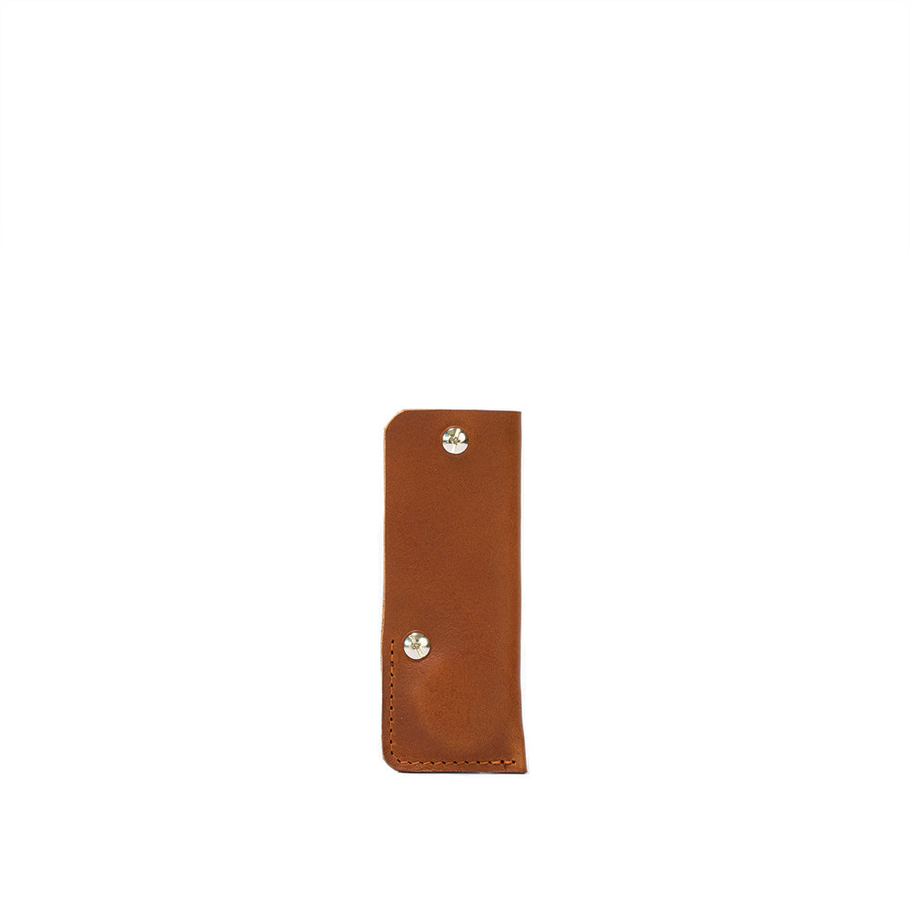 a brown leather case with silver rivets