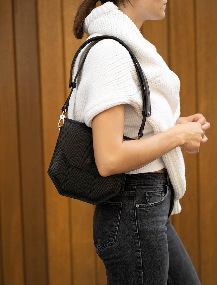 a woman wearing a white sweater and black jeans
