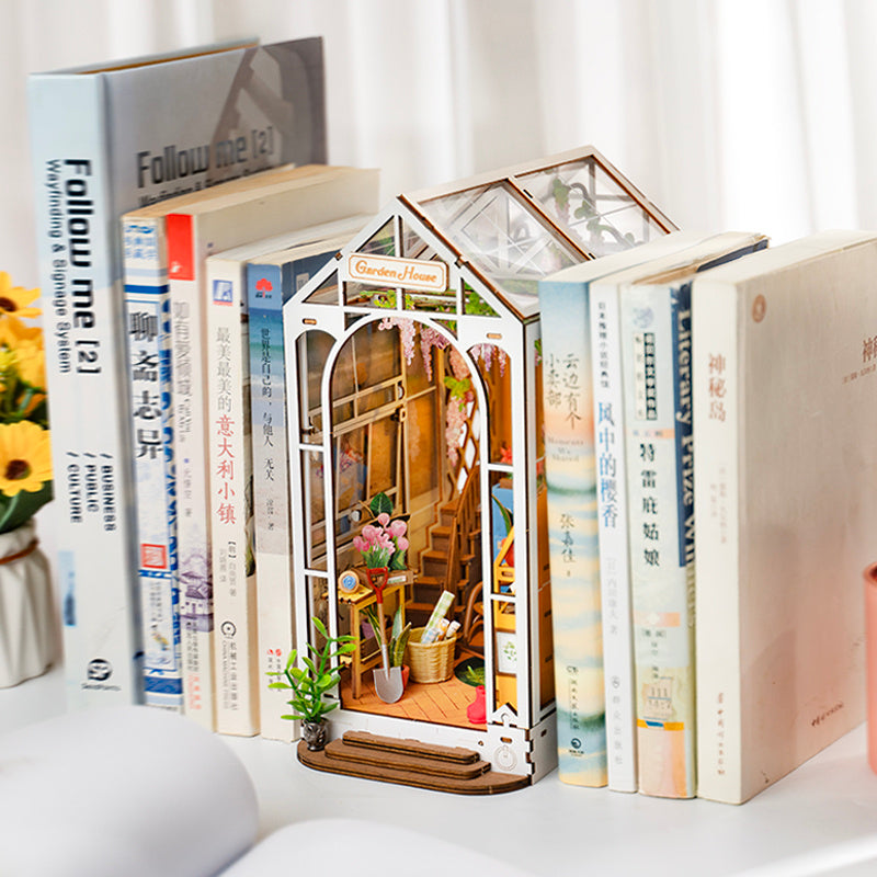 a miniature house on a shelf of books