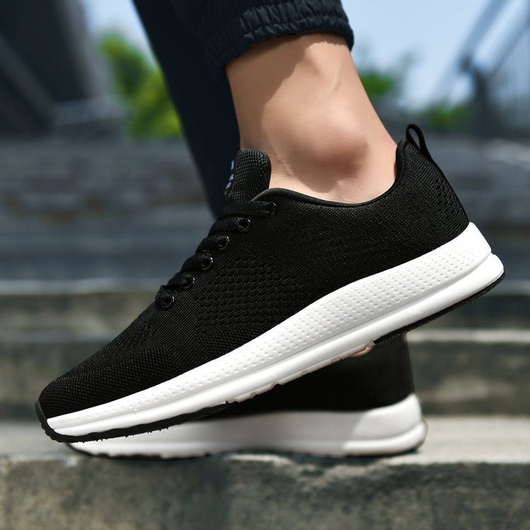 a person's foot wearing black and white sneakers