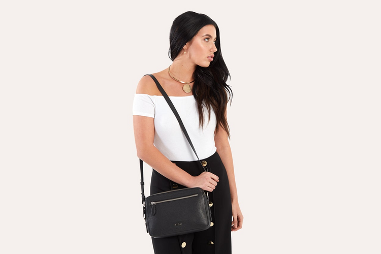 a woman holding a black purse