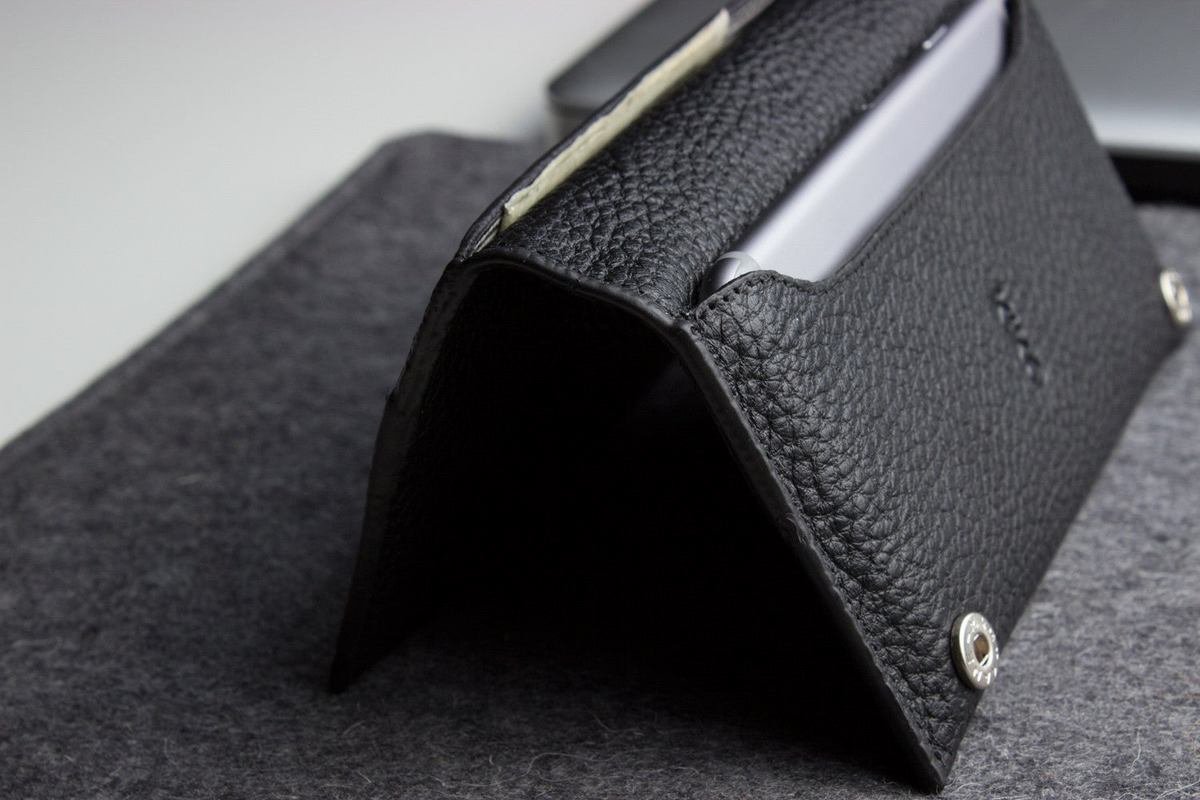 a black leather case with a cell phone in it