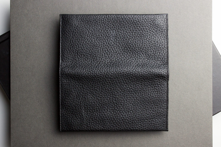 a black leather cover on a gray surface