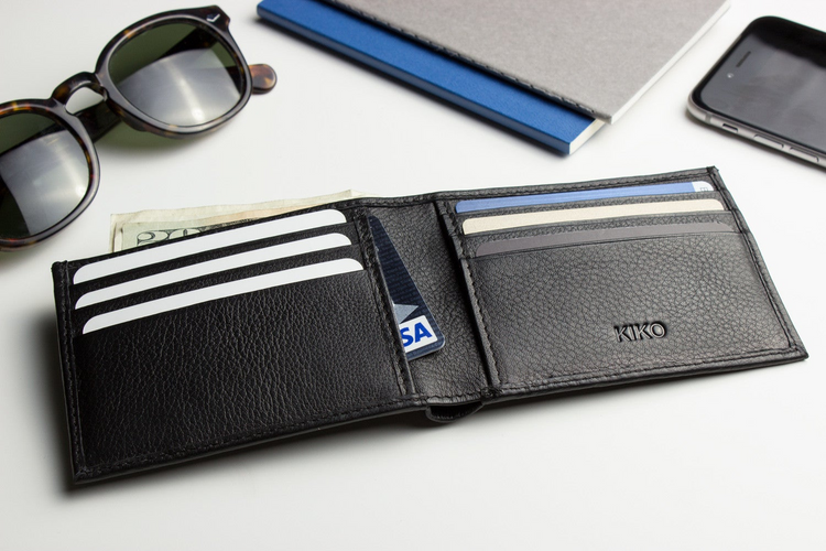 a wallet with money and glasses on a table
