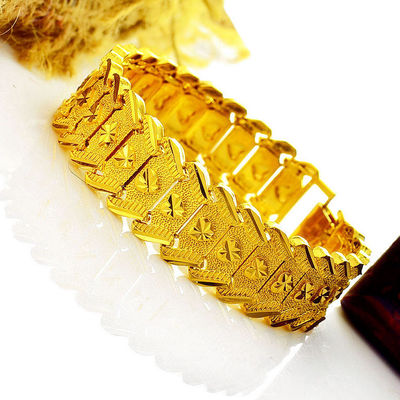 a gold bracelet on a white surface