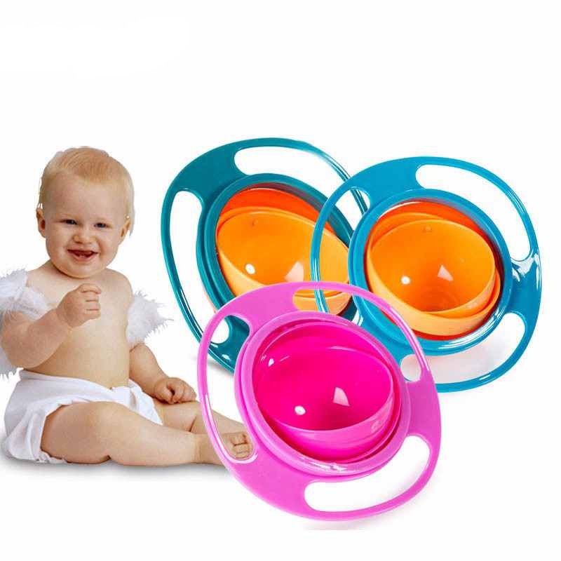 a baby sitting next to a stack of colorful bowls