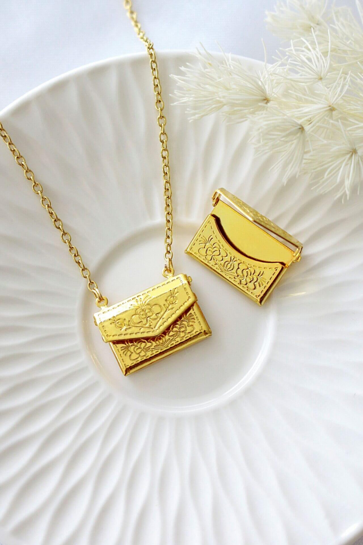 a gold necklace and pendant on a plate