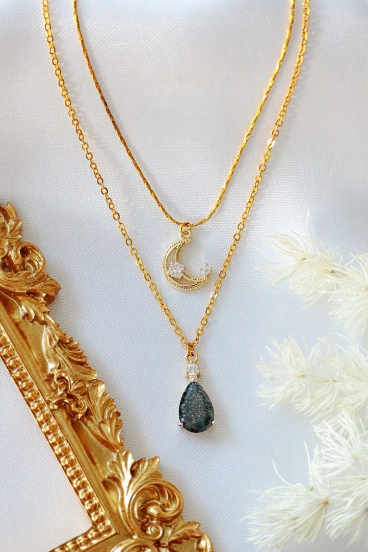 a gold necklaces with a pendant and a picture frame