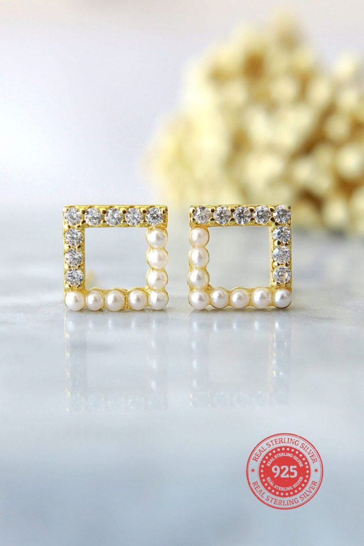 a pair of gold earrings with pearls and diamonds