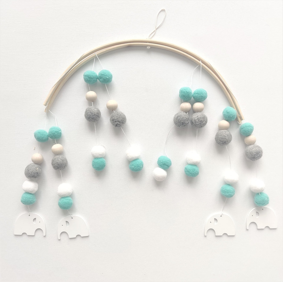 a mobile with balls and elephants on a white surface