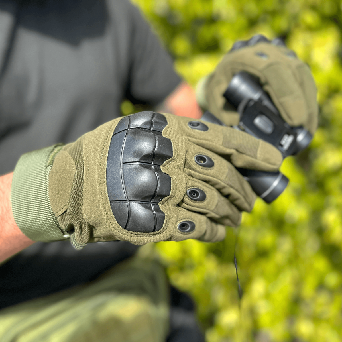a person wearing gloves holding a gun