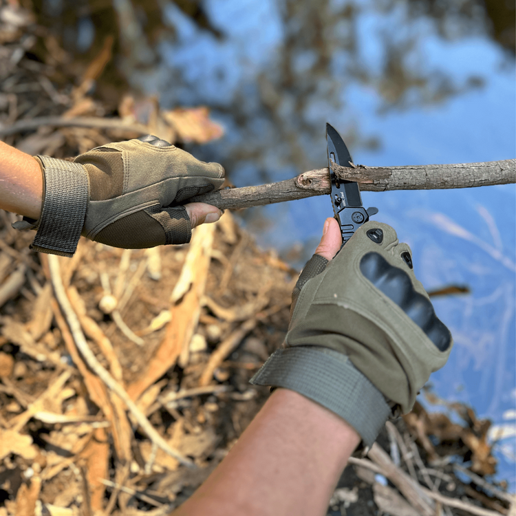 a person holding a knife to cut a branch